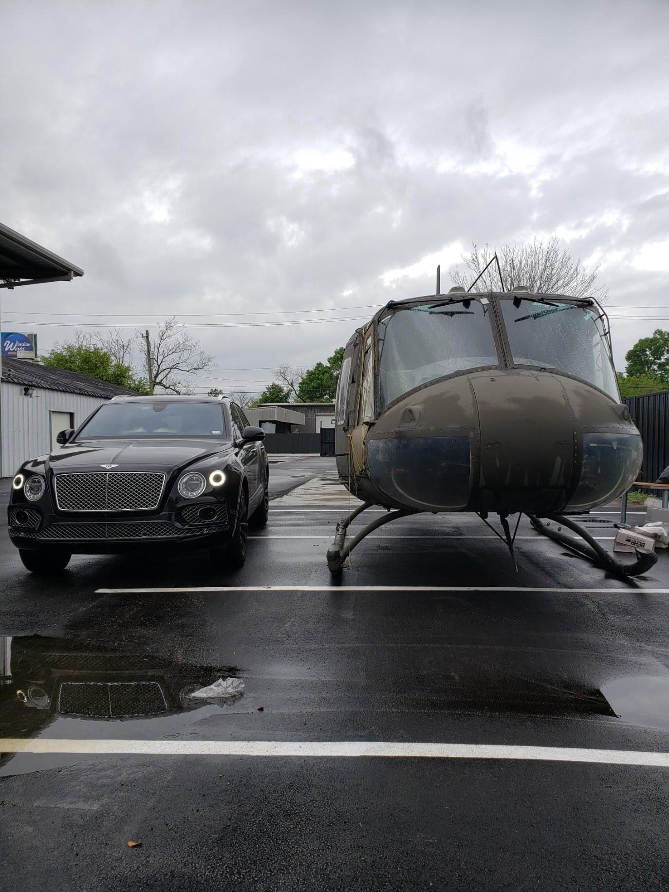 Bentley parked beside a helicopter