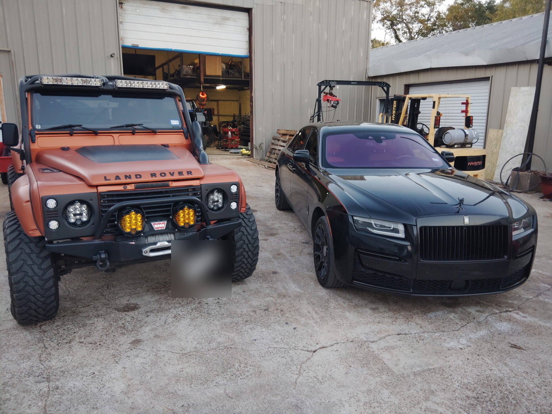 Land Rover Defender beside a Rolls-Royce