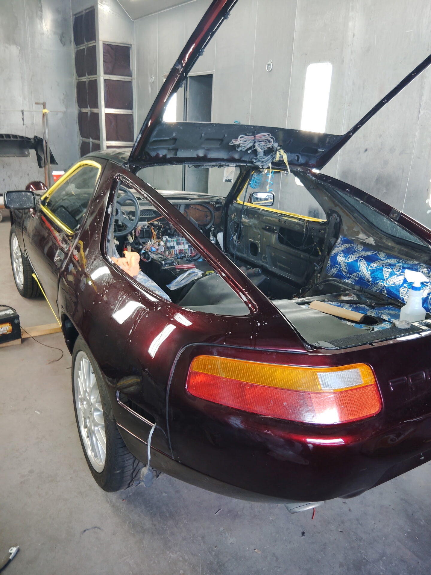Maroon Porsche 928 in the paint booth at Symphonia Werks