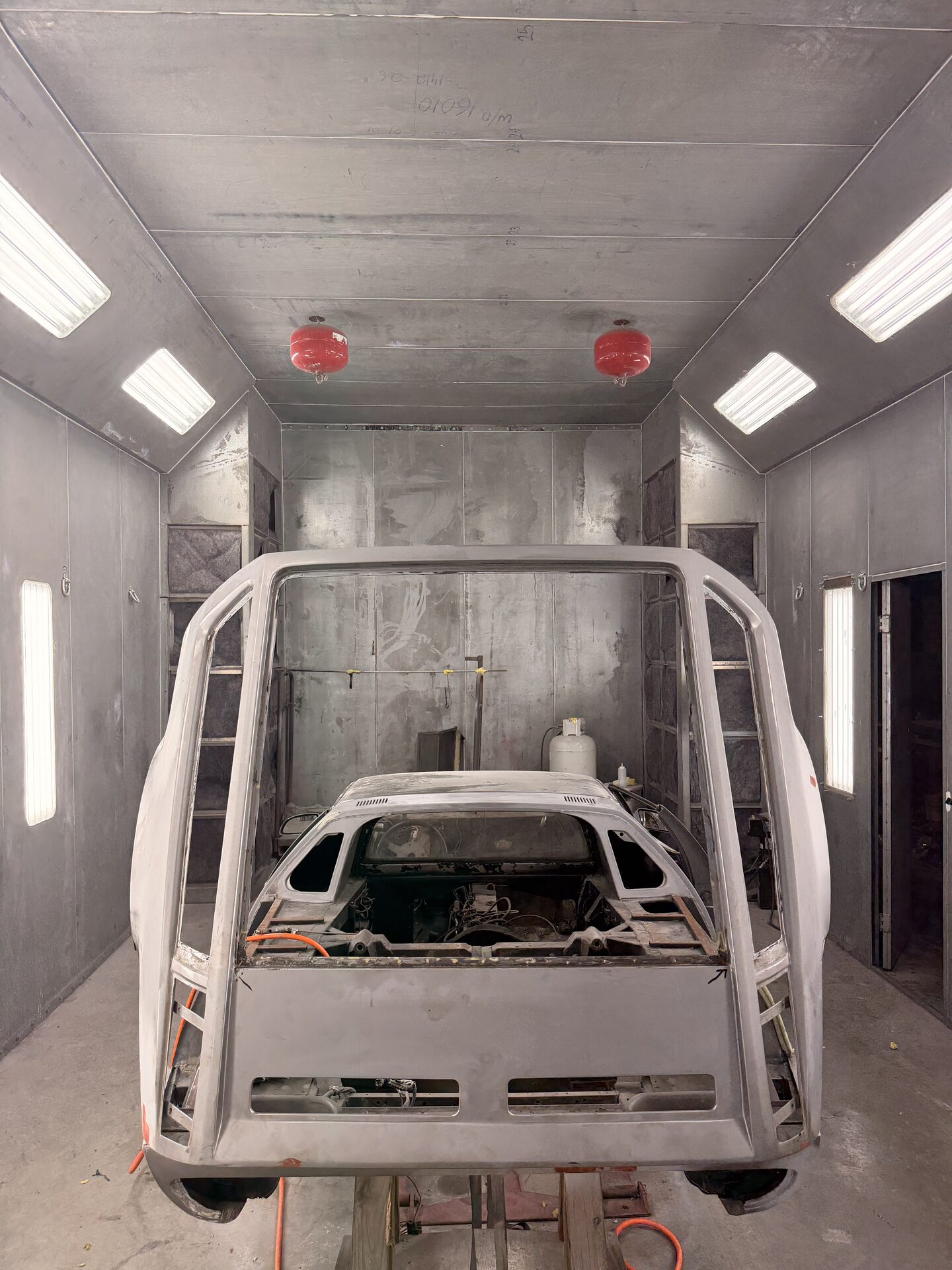 Body shell on a rotisserie in the booth